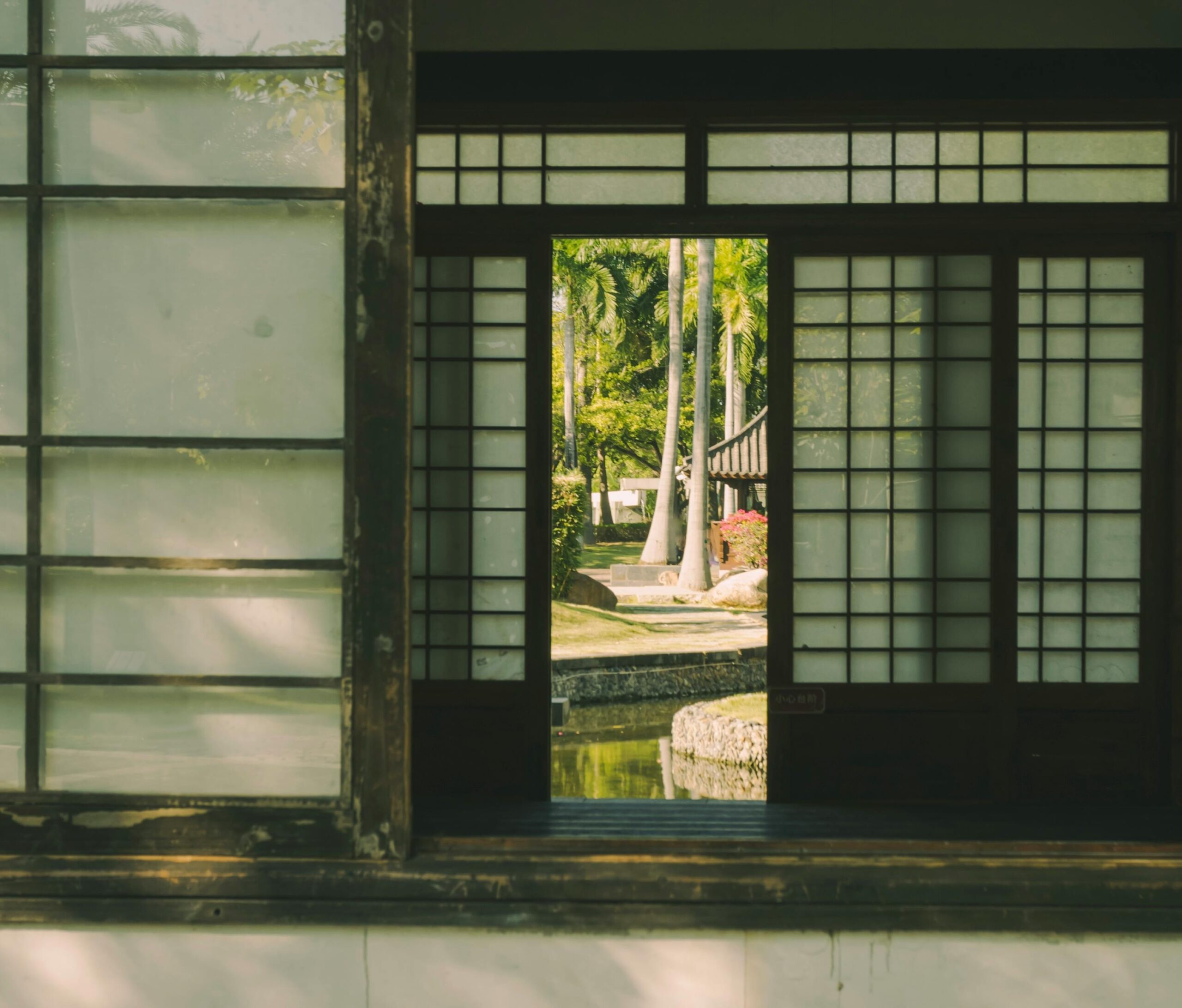 Ruhiger Blick durch japanische Shoji-Schirme, der eine friedvolle Gartenszene offenbart.